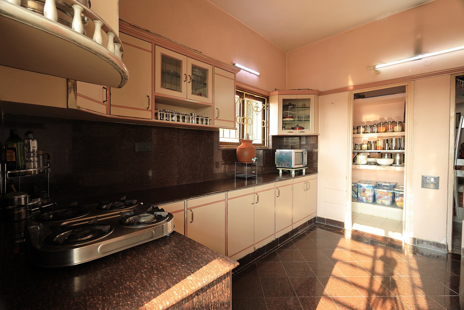 Kitchen counter and hob, with the adjoining store room stocked with essentials