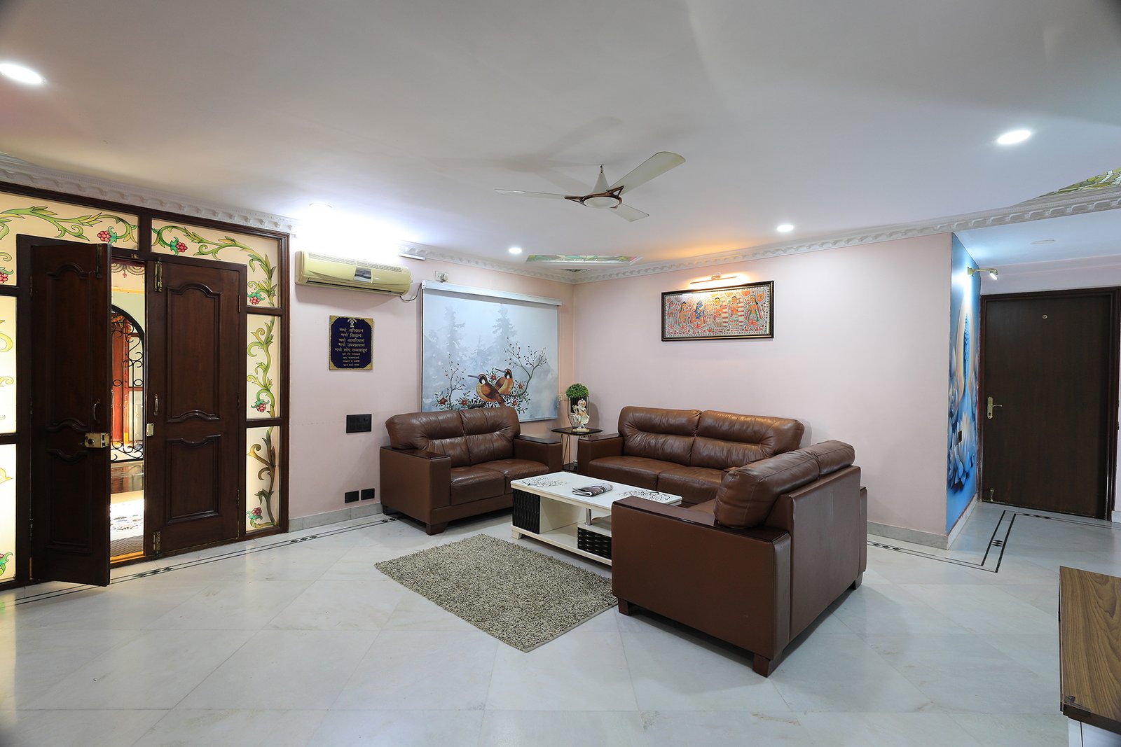 Spacious living room seating area with marble flooring, just off the entrance