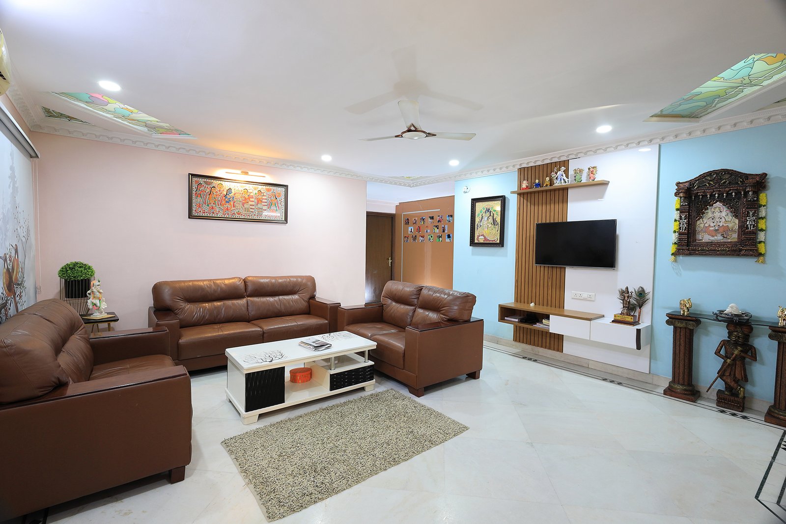 Living room TV unit with a Lord Ganesh wall art piece facing the main door for protection and peace