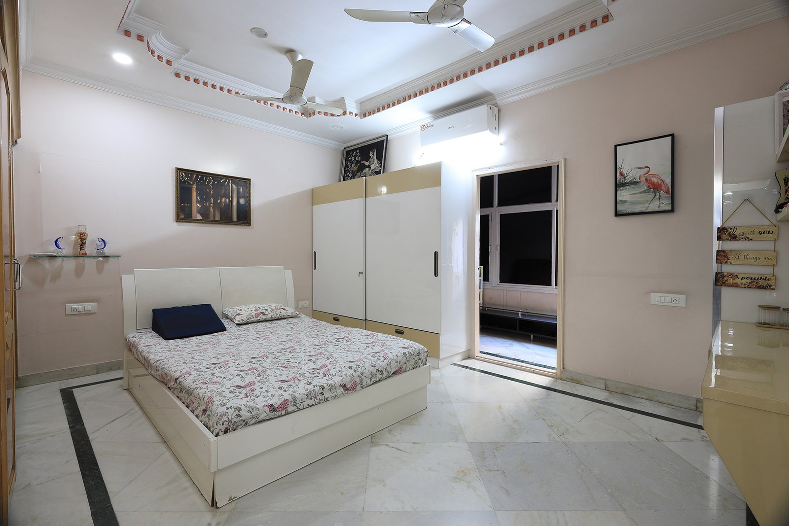 Wide view of the master bedroom with the attached balcony and dresser unit